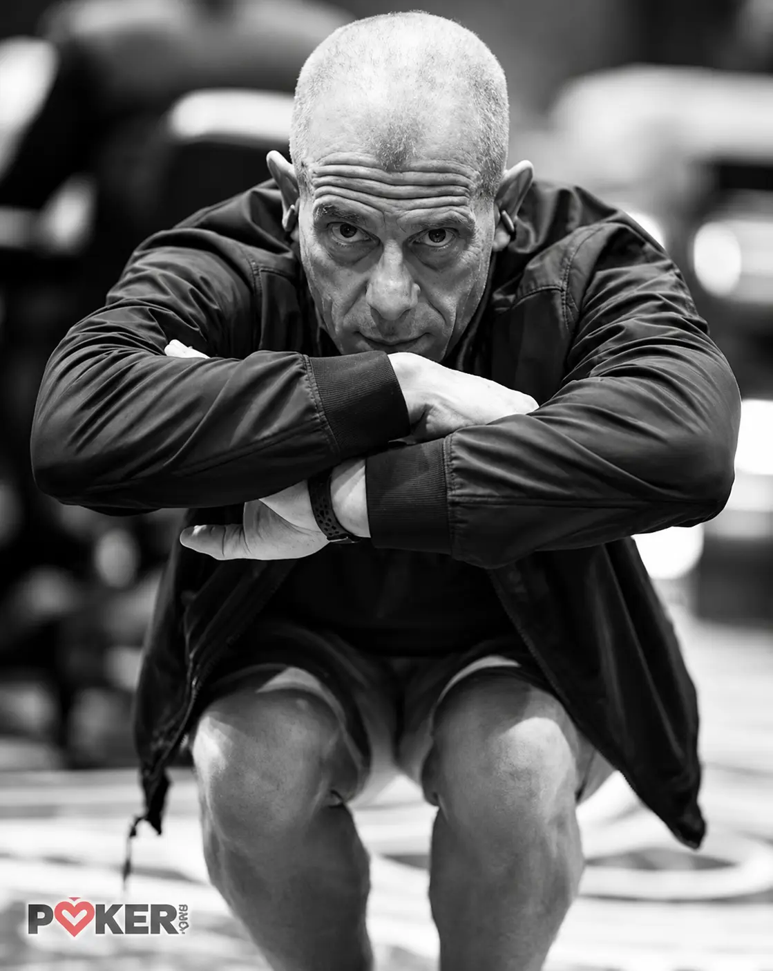 Black-and-white photograph of Will Failla with his arms crossed over his knees, credited to PokerNews.